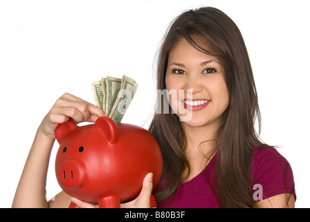 Eine junge Frau, einen hundert-Dollar-Schein in ihr Sparschwein Stockfoto