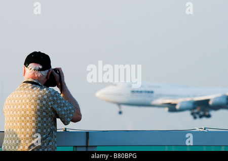 Ein Mann fotografiert ein Flugzeug landet auf dem Flughafen Hongkong Chek Lap Kok von Sky Deck. Stockfoto