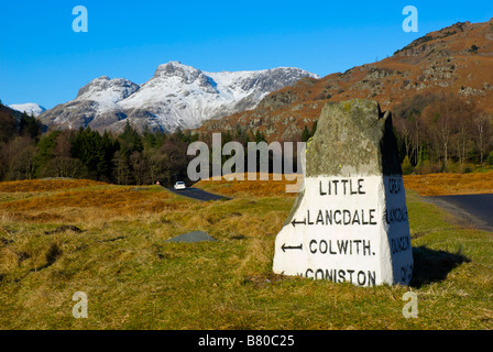 Meilenstein in der Nähe von Elterwater, Regie, entweder wenig oder Great Langdale mit Langdale Pikes in Ferne, Lake District, Cumbria Stockfoto