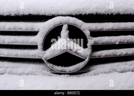 Mercedes Auto Abzeichen mit Schnee Stockfoto