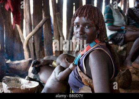 Junge hübsche Hamer Braut tun Breat Fütterung auf das Springen der feierlichen Bull Äthiopien Afrika Stockfoto