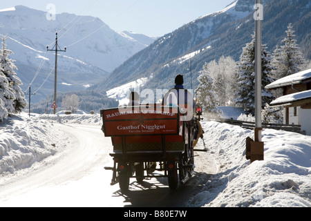 Bucheben Österreich EU Januar A Mann fahren zwei Personen in einem Pferd gezogenen Schlitten durch den Schnee bedeckt Rauriser Sonnen Tal Stockfoto