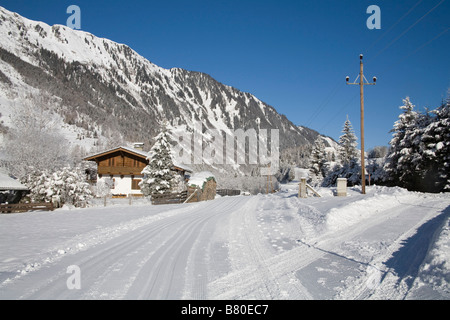 Bucheben Österreich EU Januar Suche entlang ein Winterwanderweg einen geräumten Wanderweg in Richtung einer typischen österreichischen Holzhaus Stockfoto