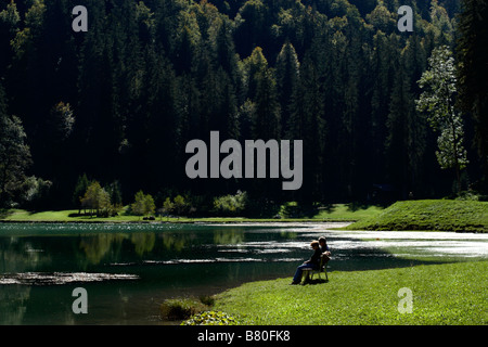 Paar, sitzen auf der Bank am See, See Montriond, Morzine, Frankreich Stockfoto