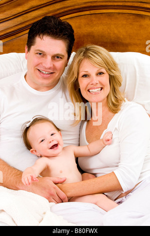 Familie mit 3 sitzen im Bett portrait Stockfoto