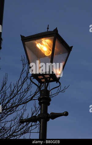 Moderne elektrische Straßenbeleuchtung in alten altmodisch Gehäuse bei Einbruch der Dunkelheit beleuchtet. Stockfoto