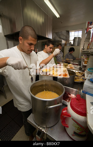 Freiwillige Kochen traditionelles Weihnachtsessen während Urlaubsaktivitäten für einkommensschwache Einheimischen in einem Obdachlosenheim in Barstow CA Stockfoto