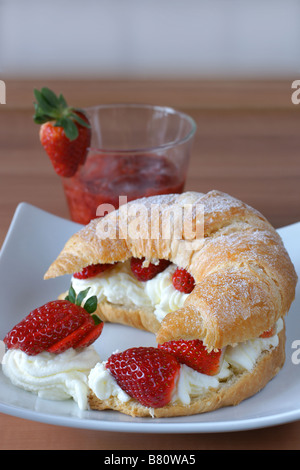 Frische Croissant gefüllt mit Sahne und frischen Erdbeeren Stockfoto