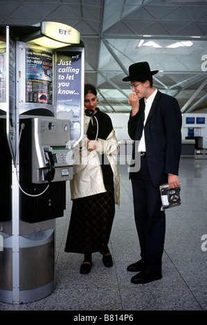 7. Oktober 2003 - orthodoxe Juden nach Hause anruft von einer öffentlichen BT-Telefonzelle in Stansted Flughafen Abflughalle. Stockfoto