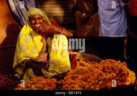 Ein Rajasthani Frau verkaufen orange Chrysanthemen in Jaipur, Indien Stockfoto