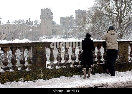 Menschen fotografieren Warwick Castle im Schnee von der Brücke, Warwick, Warwickshire, England, UK Stockfoto