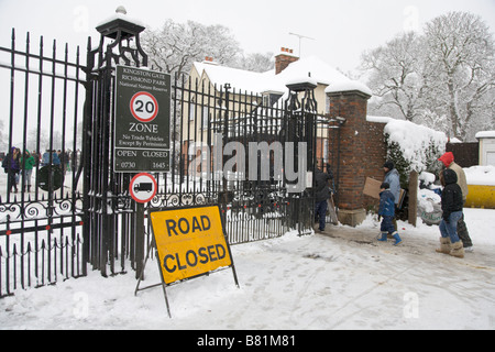 Familien am Tag geben Sie Richmond Park mit improvisierten Rodeln im verschneiten Wetter Winter 2009 Stockfoto