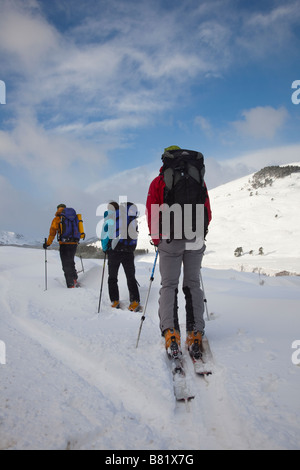 Schottische Schneelandschaft mit drei Personen Skifahren. Männliche & weibliche Skifahrer nach Schneefall, Braemar, Cairngorms National Park, Highlands, Schottland, Großbritannien Stockfoto