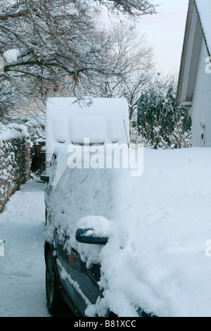 Ein Auto und Wohnwagen sind mit Schnee bedeckt. Stockfoto