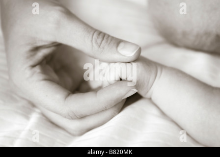 Mutter halten Babys hand Stockfoto
