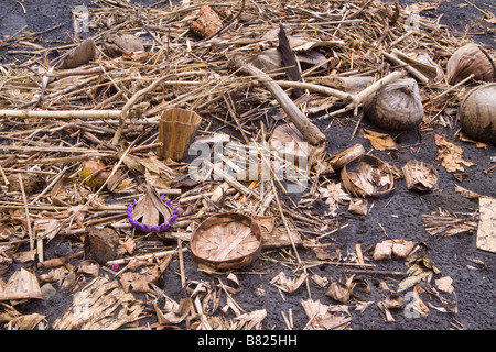 Kokosnüsse, gewebte Palm bietet Körbe und Müll, angespült auf einem schwarzen Sandstrand in Bali, Indonesien Stockfoto