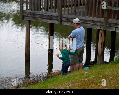 Vater, Sohn und Tochter in einem kleinen Teich zu Fischen Lehren Stockfoto