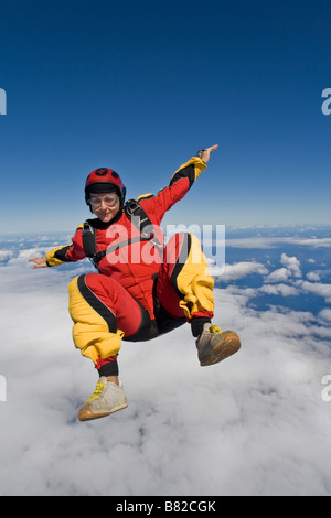 Fallschirmspringer ist sitzen über eine große Wolke am blauen Himmel fliegen und dabei Spaß haben. Die Uferlinie auf der Rückseite ist als Referenz zu tauchen. Stockfoto