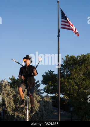 Straßenkünstler jongliert Feuer während der Fahrt Einrad Mallory Square Key West Florida Stockfoto