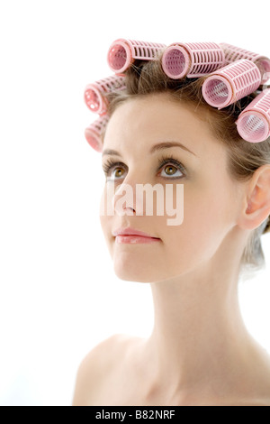 Porträt der jungen Frau mit Lockenwickler auf Kopf Seitenansicht Stockfoto