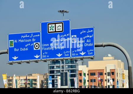 Dubai blau zweisprachige Autobahn Ausfahrt Straße Ziel Route Zeichen Gantry über Verkehr sonnige Stadtlandschaft Vereinigte Arabische Emirate VAE Naher Osten Stockfoto