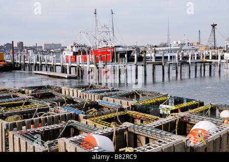 Nautische winter Szene an der Marina mit Reusen und Bojen im Vordergrund Eis in Wasser und kommerziellen Fischerboote am Dock w/Conch angeln Töpfe Stockfoto