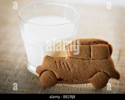 Glas Milch und Auto Form Cookie auf Leinen Tischdecke Stockfoto