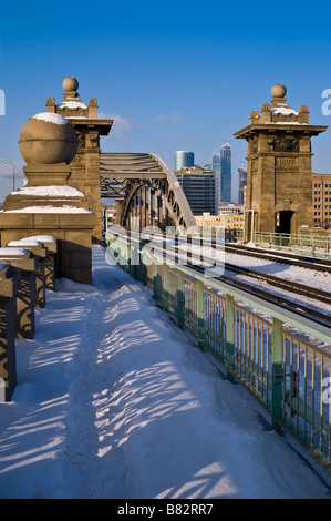 Eisenbahnbrücke in Moskau an einem sonnigen Wintertag mit Türmen der Moscow International Business Center im Hintergrund Stockfoto