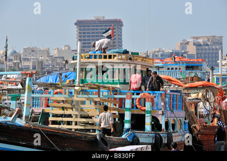 Dubai Creek Seeleute Arbeiter auf Dhow-Boot mit Fracht beladen & Merchandise auf überfüllten Hafenkai Vereinigte Arabische Emirate VAE Naher Osten Stockfoto