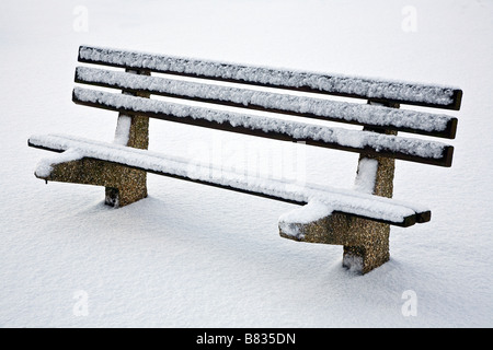 Einsame Parkbank im Schnee Stockfoto