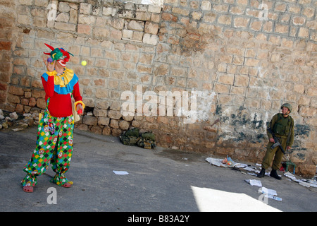 Israelische Siedler gekleidet wie ein Clown, Purim, ein jüdisches religiöses fest, in der West Bank Siedlung Hebron zu feiern. Stockfoto