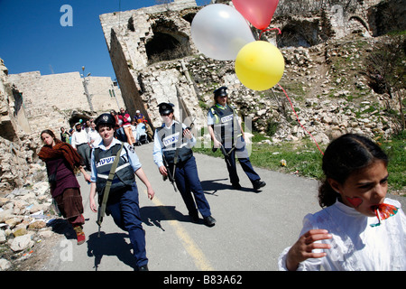 Israelische Polizei eskortiert israelische Siedler durch die alte Stadt von palästinensischen Hebron während Purim feiern. Stockfoto