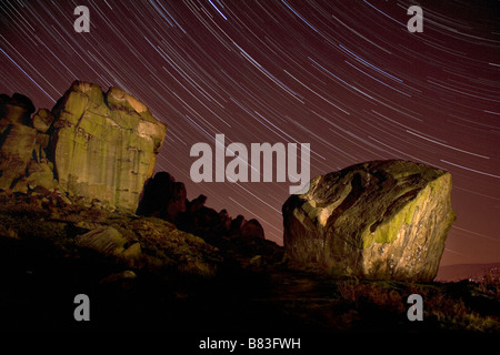 Sternspuren über die Kuh und Kalb Felsformation auf Ilkey Moor, West Yorkshire, England Stockfoto