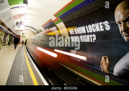 Ein "Lost"-Plakat wird aufgedeckt, wie eine u-Bahn der Piccadilly Linie die Plattform in Holborn Station, London, England verlässt. Jan 2009. Stockfoto