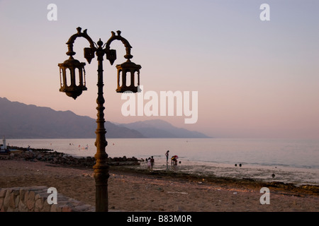 Einheimischen Beduinen Familien entspannen Sie am Strand den Sonnenuntergang über Asilah im Ferienort Dahab Sinai in Ägypten Stockfoto