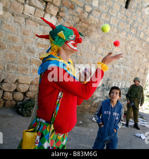 Israelische Siedler gekleidet wie ein Clown, Purim, ein jüdisches religiöses fest, in der West Bank Siedlung Hebron zu feiern. Stockfoto