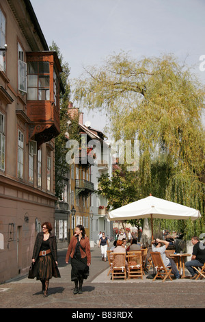 Cafe Tische säumen den Bürgersteig entlang des Flusses Ljubljanica auf Jurcicev Trg in der Hauptstadt Ljubljana, Slowenien Stockfoto