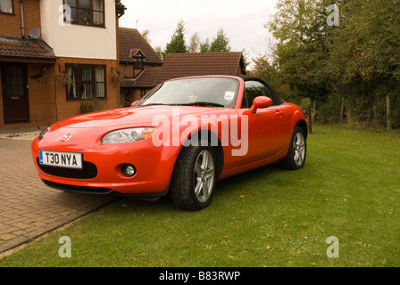 Ein roter Sportwagen Mazda mx5 geparkt auf einem Laufwerk vor einem Haus Stockfoto