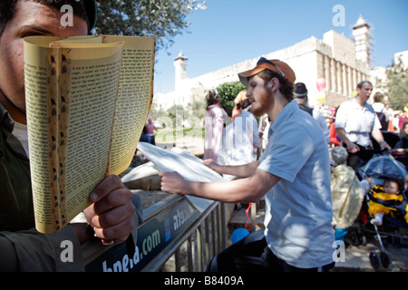 Israelische Polizisten einen jüdischen religiösen Text zu lesen, während Purim feiern in Hebron. Stockfoto