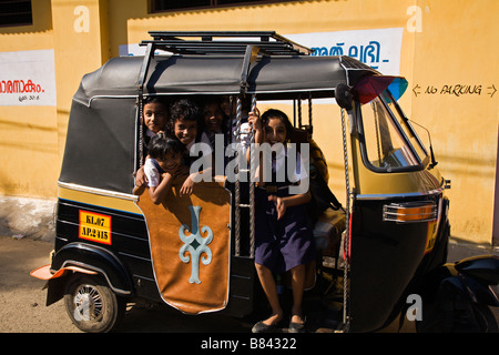 Schulmädchen warten in ihrer Schule Dreirad taxi in Fort Cochin, Kerala Zustand, Indien Stockfoto