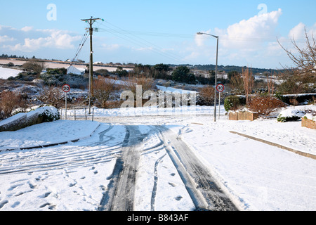 Schnee und Eis auf einer Straße in einer Wohnsiedlung in Cornwall UK. Stockfoto