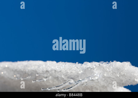 Ein blauer Himmel mit Eiszapfen Traufe Wasser, Schnee und Eis Stockfoto