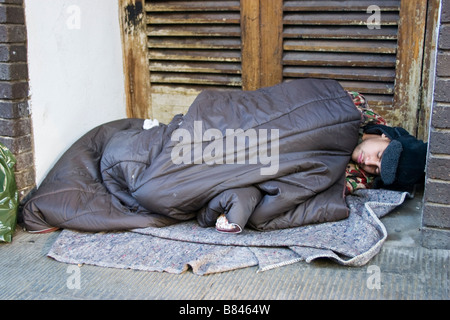 Obdachloser schlafen rau in einer Tür-Oxford-Bluse Stockfoto