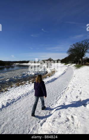 Walker auf Pfad neben gefrorenen Fluss Dee in der Stadt Aberdeen, Schottland, UK, mit riesigen Brocken aus Eis und Schnee im Winter. Stockfoto