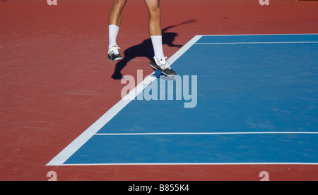 Tennis-Spieler in der Luft wie sie dienen Stockfoto