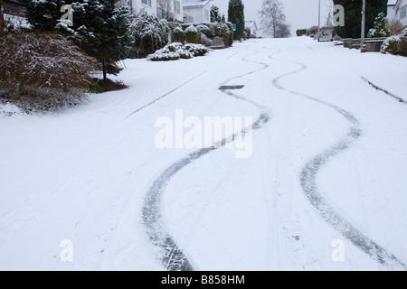 Bremsspuren in den Schnee von einem Auto auf einer steilen Straße in Ambleside UK Stockfoto