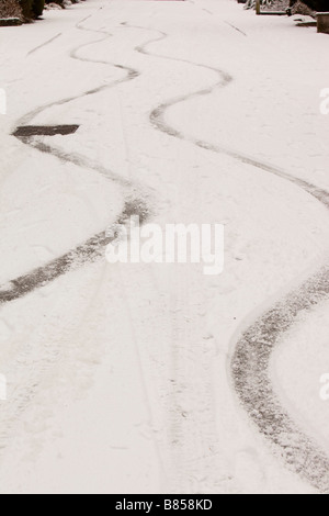 Bremsspuren in den Schnee von einem Auto auf einer steilen Straße in Ambleside UK Stockfoto