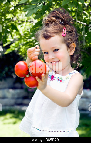 Porträt von kleinen Mädchen mit Tomaten Stockfoto