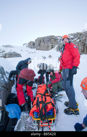 Ein Navy Sea King Hubschrauber Crew und Mountain Rescue Team-Mitglieder behandeln eine schwerverletzter walker Stockfoto