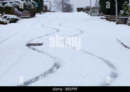 Bremsspuren in den Schnee von einem Auto auf einer steilen Straße in Ambleside UK Stockfoto